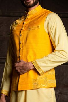 Editor's Note Featuring A Lemon Kurta Dhoti With Kurta And Yellow Raw Silk Jacket Embroidered With Resham, Patra And Beadwork Color: Yellow Fabric: Bundi: Raw Silk, Kurta: Viscose Silk, Dhoti: Modal Satin Component: Bundi, Kurta And Dhoti Embroidery Details: Resham, Patra And Beadwork Care: Dry Clean Only About the Designer Nitika Gujral’s journey with designing clothes started almost four decades back while she was still in high school and held her first exhibition for family and friends. Makin Festive Cotton Silk Bandhgala With Resham Embroidery, Ceremonial Cotton Silk Sherwani With Resham Embroidery, Ceremonial Cotton Silk Bandhgala With Zari Work, Bollywood Style Embroidered Cotton Silk Bandhgala, Bollywood Style Designer Cotton Silk Bandhgala, Festive Cotton Silk Bandhgala With Traditional Drape, Diwali Cotton Silk Bandhgala With Intricate Embroidery, Traditional Cotton Silk Nehru Jacket With Cutdana, Traditional Nehru Jacket In Cotton Silk With Cutdana