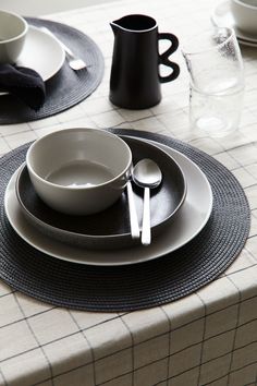 the place setting is ready to be served for two people at this table with black and white dishes