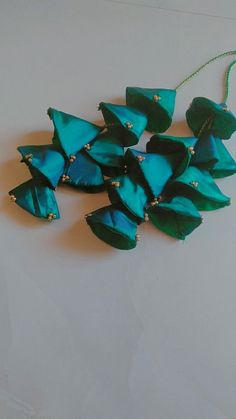 a group of blue and green necklaces sitting on top of a white table next to each other