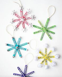 four snowflake ornaments are hanging from string