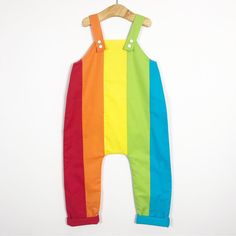 Our Rainbow dungarees are made from 100% premium quality cotton. The fabric has a stunning look and feel and each fabric colour has been carefully selected. The rainbow is repeated on the back as well as on the front of the dungarees.  The length is adjustable on the shoulders using KAM snap fasteners. The length of the legs can also be adjusted as the turn ups can be turned up further and un-rolled as your little one grows. All our dungarees are fully lined with a light soft cotton. Dropped crotch for plenty of nappy room wether you use cloth or disposable nappies. Our dungarees have been made to have a slouchy comfortable fit that both looks and feels amazing! Do check our size guide below to find the best size for your child based on their height.  0-3 months: up to 62cm  3-6 months: 62 Playful Cotton Overalls For Spring, Striped Cotton Jumpsuits And Rompers For Summer, Summer Striped Cotton Jumpsuits And Rompers, Playful Green Cotton Jumpsuits And Rompers, Striped Cotton Jumpsuits And Rompers For Spring, Spring Striped Cotton Jumpsuits And Rompers, Spring Multicolor Cotton Jumpsuits And Rompers, Playful Cotton Shortalls, Playful Cotton Shortalls For Summer