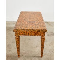 an orange table sitting on top of a cement floor