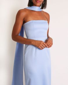 a woman wearing a light blue dress with an asymmetrically shaped neckline