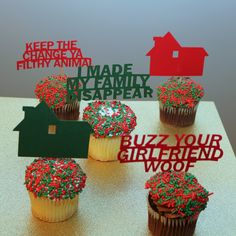 cupcakes with red and green sprinkles sitting on top of a table