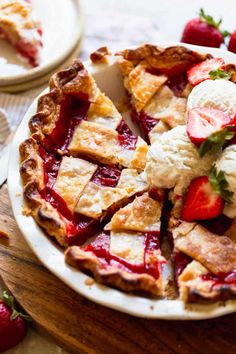 a strawberry pie with ice cream and strawberries on the side, ready to be eaten