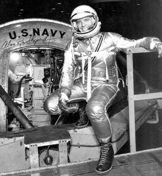 an astronaut sitting on the back of a space shuttle in front of a u s navy sign