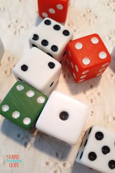 several dices sitting on top of a table with white and black dots around them