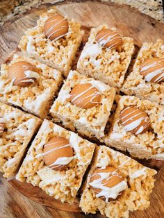 several pieces of rice krispy treats are arranged on a wooden platter with white icing