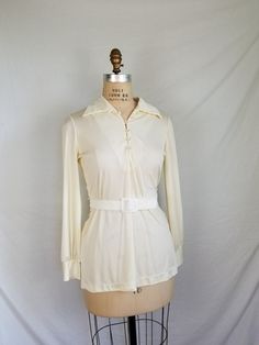 Good vintage condition, great style. Belt included. Nylon Cream color The belt is a little lighter/whiter than the blouse, but it came with it so I'll include it. 38 bust 16 shoulders 24 sleeve 28 CB 34 waist Chic Fitted Belted Blouse, Fitted Long Sleeve Belted Top, Belted Long Sleeve Blouse For Fall, Retro Cream Blouse For Formal Occasions, Cream Retro Blouse For Formal Occasions, Fitted Cream Blouse With Collar, Vintage Collared Cream Blouse, Beige Blouse, Romantic Blouses