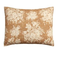 a brown and white pillow with flowers on it