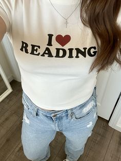 a woman with long hair wearing jeans and a t - shirt that says i love reading