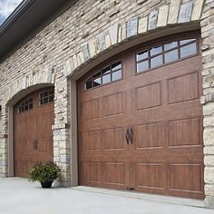 two large brown garage doors in front of a brick building with an attached planter