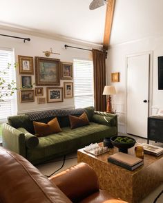 a living room with couches, tables and pictures on the wall in it's corner