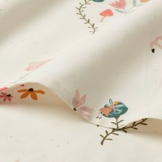 the fabric is white with flowers and birds on it's back side, as well as