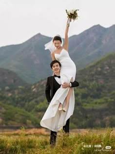 a man holding a woman on his back while she holds her up in the air