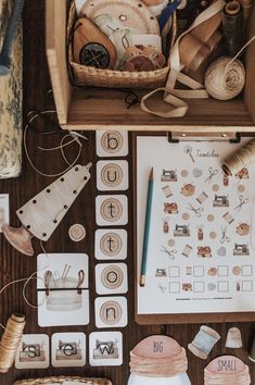 the contents of a sewing kit laid out on top of a wooden table next to thread, scissors and other crafting supplies