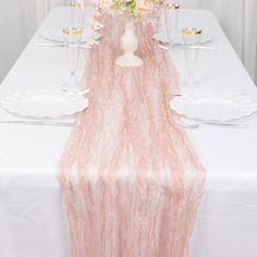 the table is set with white and pink flowers