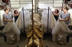 three women are looking at dresses on racks