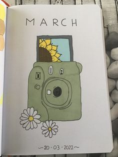 an open book with a drawing of a camera and sunflowers on the cover