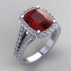 a ring with a red stone surrounded by diamonds