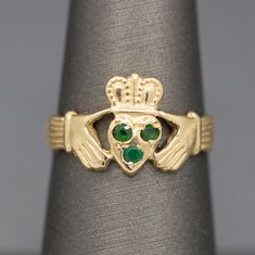 Vintage Three Stone Emerald Claddagh Engagement Wedding Ring in 14k Yellow Gold This lovely ring symbolizes the friendship, love and loyalty in a marriage.  The ring also features three round prong set natural emeralds measuring about 2mm each.  From front to back the ring measures 11.26mm.  The band narrows just slightly in the back.  The ring is crafted in solid 14k yellow gold (stamped) and weighs 3.08g.  The ring is currently a size 6.5 and can be resized before shipment for a fee, please as Three Stone Rings For Promise With May Birthstone, Promise Three Stone Emerald Ring, Gold Three Stone Ring For May Birthstone, Claddagh Ring, The Friendship, Claddagh Rings, Friendship Love, Etsy Wedding Rings, Engagement Wedding Ring