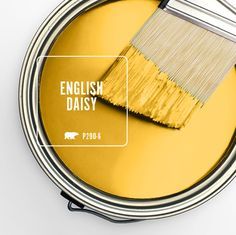 a paint can with a brush in it and the words english daisy painted on it