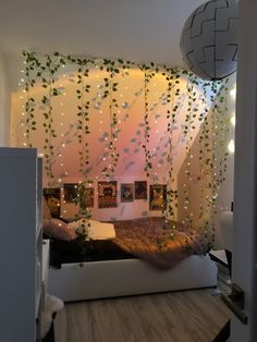 a bedroom with plants growing on the wall and lights hanging from the ceiling above it