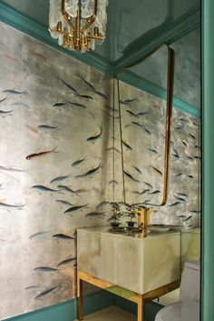 a bathroom with fish painted on the wall next to a mirror and sink in it