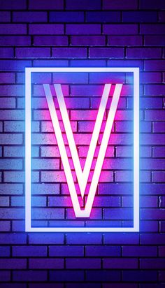 a neon sign on the side of a brick wall that has a v in it