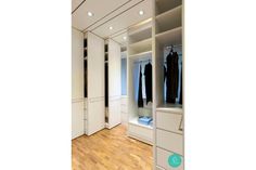 an empty walk in closet with white cabinets and drawers