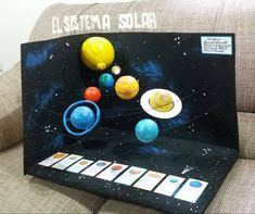 a solar system made out of paper and some sort of magnet on the back of a couch