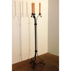 a tall metal pole with two candles on it's side and three smaller ones behind it