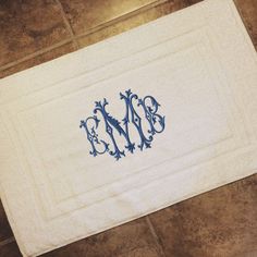 an embroidered monogrammed bath mat on the floor