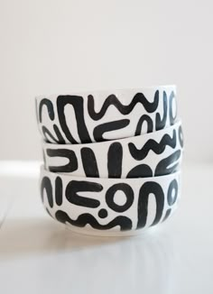 three black and white bowls sitting on top of a table