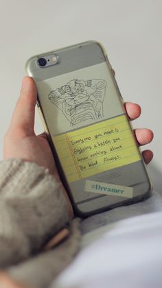 a person holding an iphone with a note attached to it