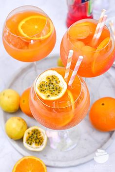 two glasses filled with orange juice and garnished with pomegranates