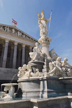 the statue is in front of the building with many statues on it's sides