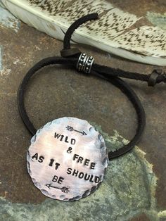 Wild and Free As It Should Be bracelet is a handmade beauty any free spirited boho cowgirl will boldly and proudly wear. This showpiece has a gorgeous medallion featuring arrows and hand stamped lettering. Handmade in Idaho by Weathered Soul exclusively for Bourbon Cowgirl. Limited Edition, high quality jewelry that is as unique and authentic as you! Due to their handcrafted nature, slight variations will occur. The feel and design of the product will remain true to the overall aesthetic. Featur Inspirational Adjustable Hand Stamped Jewelry, Personalized Bohemian Jewelry For Festival, Nickel-free Bohemian Jewelry For Friendship, Adjustable Stamped Bracelets For Festivals, Adjustable Stamped Jewelry For Festivals, Bohemian Hand Stamped Bracelets For Gift, Bohemian Hand Stamped Bracelets For Gifts, Bohemian Hand Stamped Bracelets As Gift, Bohemian Stamped Bracelets As Gift