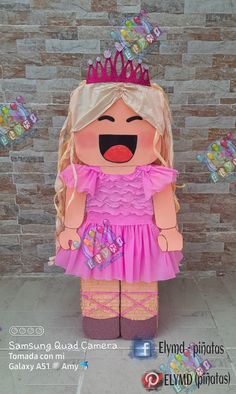 a large paper doll with a pink dress and tiara on it's head