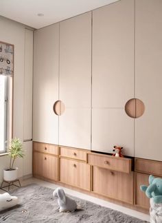 a bedroom with white walls and wooden furniture in the corner, along with two stuffed animals