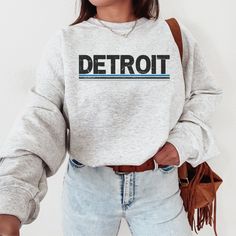 Show off your passion for Detroit football with this vintage-style Lions sweatshirt. With its classic crewneck design and retro Lions shirt print, this sweatshirt is the perfect gift for any Lions football fan. Whether you're cheering them on from the sidelines or watching the game at home, this Michigan Lions gift is a must-have addition to your collection. Stay cozy and stylish while showing your team pride with this timeless sweatshirt. This is a looser fit sweatshirt, but we recommend sizing Throwback Letter Print Sweatshirt For Fall, Casual Mascot Sweatshirt For Game Day, Fall Throwback T-shirt With Letter Print, Detroit Lions Game Day Outfit, Fall Throwback Letter Print T-shirt, Retro Crew Neck Sweatshirt For Fan Merchandise, Retro Game Day Sweatshirt With Letter Print, Fan Merchandise Text Print Crew Neck Sweatshirt, Detroit Lions Outfit Woman