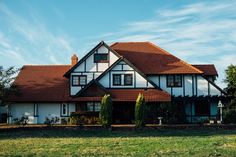 a large white and brown house with red roof