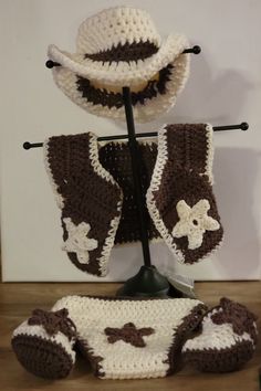 a crocheted hat, diaper cover and booties are on display