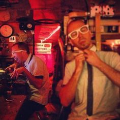 two men wearing ties and glasses in a bar