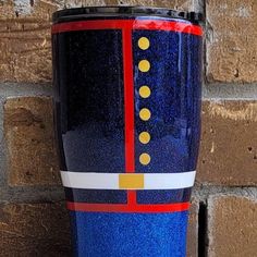 a blue and red coffee cup sitting next to a brick wall