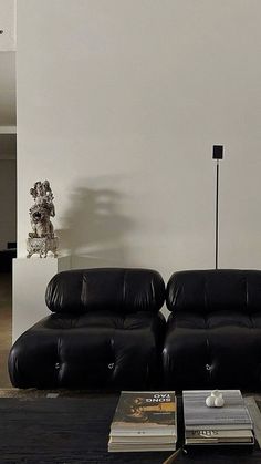 a living room with two black leather couches