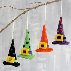 four felt witches hanging from a tree branch