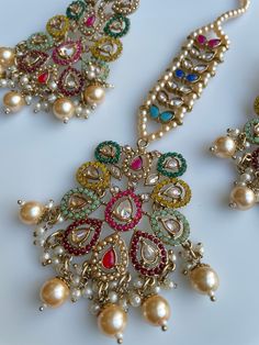 These gorgeous sets of tikka and jhumka come in 2 beautiful colors and are pastel tones to match any outfit. The multi set is a subtle mix of colors to create a uniform look and the champagne is the perfect single pop of color for any outfit! Comes as a set of earrings and headpiece (tikka) Elegant Multicolor Sets With Stone Work, Elegant Multicolor Kundan Jhumkas, Elegant Multicolor Jhumkas For Festive Occasions, Elegant Multicolor Stone Work Chandbalis, Elegant Multicolor Chandbalis With Stone Work, Elegant Multicolor Chandbalis For Festive Occasions, Elegant Multicolor Festive Chandbalis, Elegant Multicolor Kundan Chandbalis, Elegant Multicolor Jhumkas For Celebration