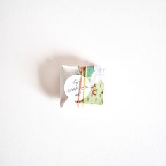 an origami shaped piece of paper sitting on top of a white surface