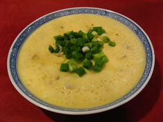 a bowl of soup with green onions and celery